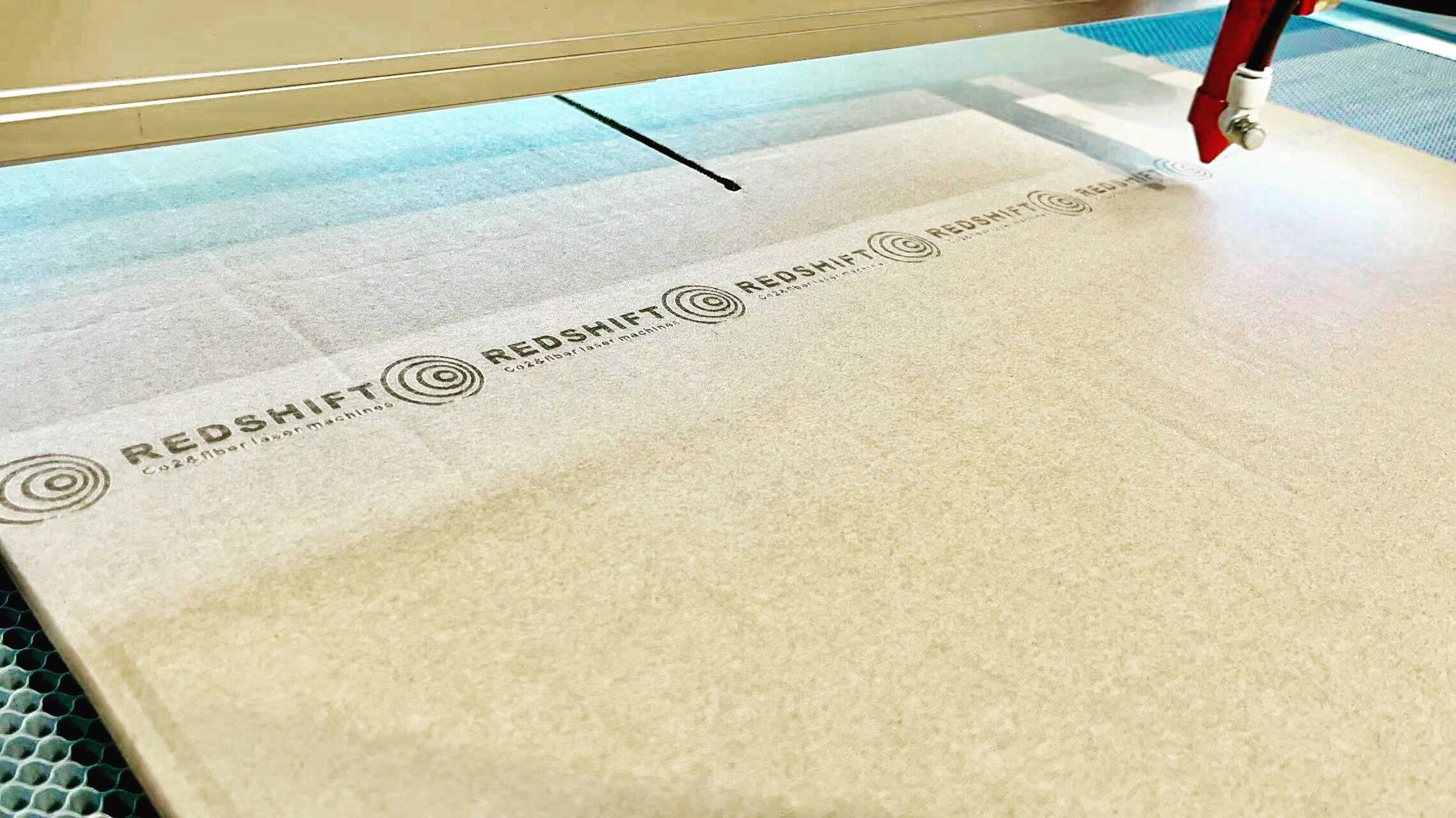 A packaging manager inspecting a CO2 laser machine on a factory floor