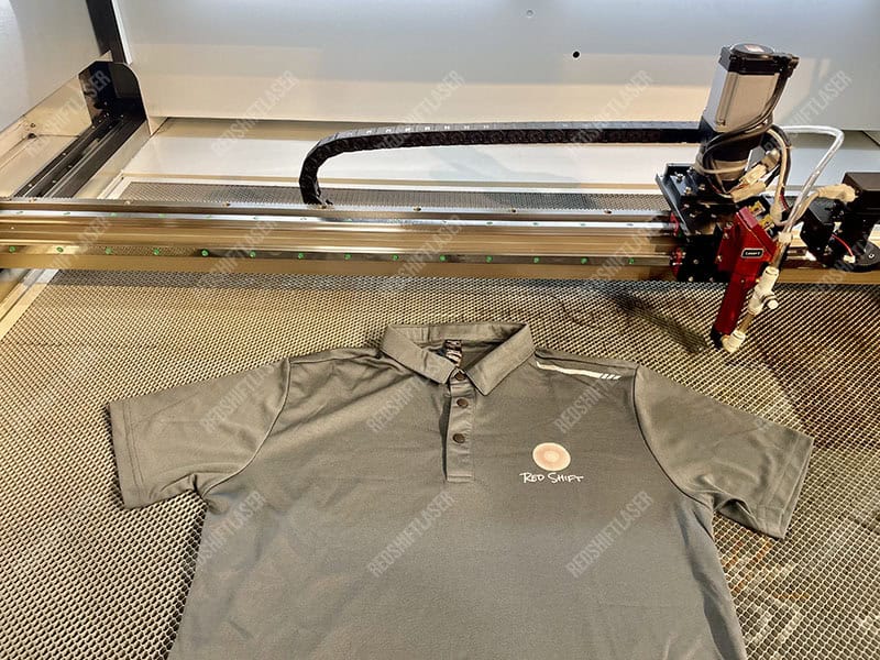 A technician performing a routine cleaning of a CO2 laser machine's lens