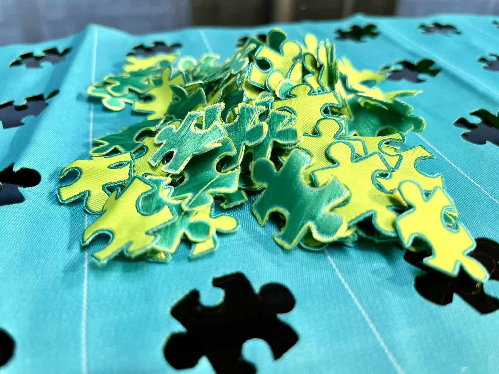 A computer screen showing a digital patch design file being sent directly to a laser cutter, which is already cutting the final product