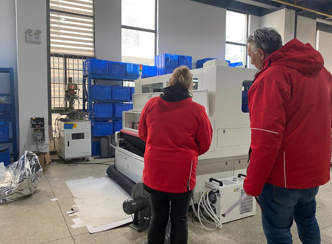 A Redshift Laser CO2 machine with a camera system mounted above the cutting bed, poised over a sheet of leather with printed markers