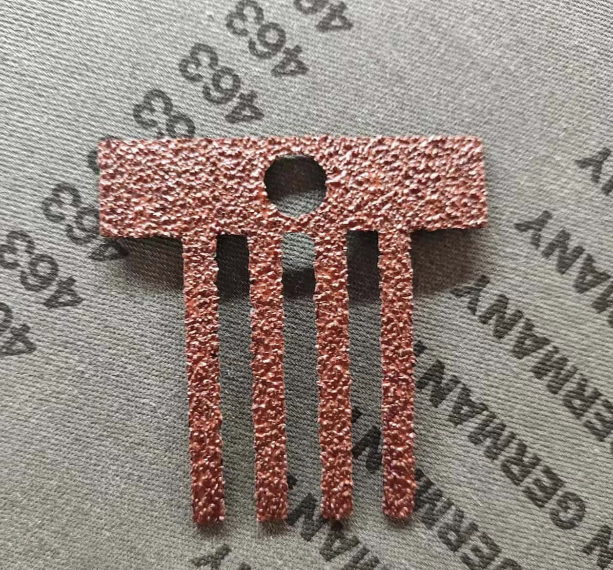 CO2 Laser Cutting Sandpaper A CO2 laser cutter precisely cutting intricate shapes out of a sheet of sandpaper with no visible dust or fraying