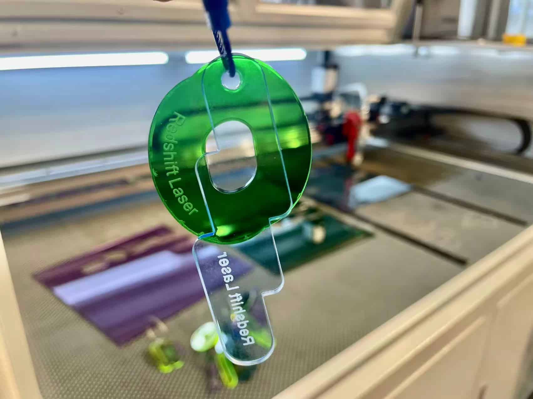 A close-up of a laser engraved logo on a dark leather wallet