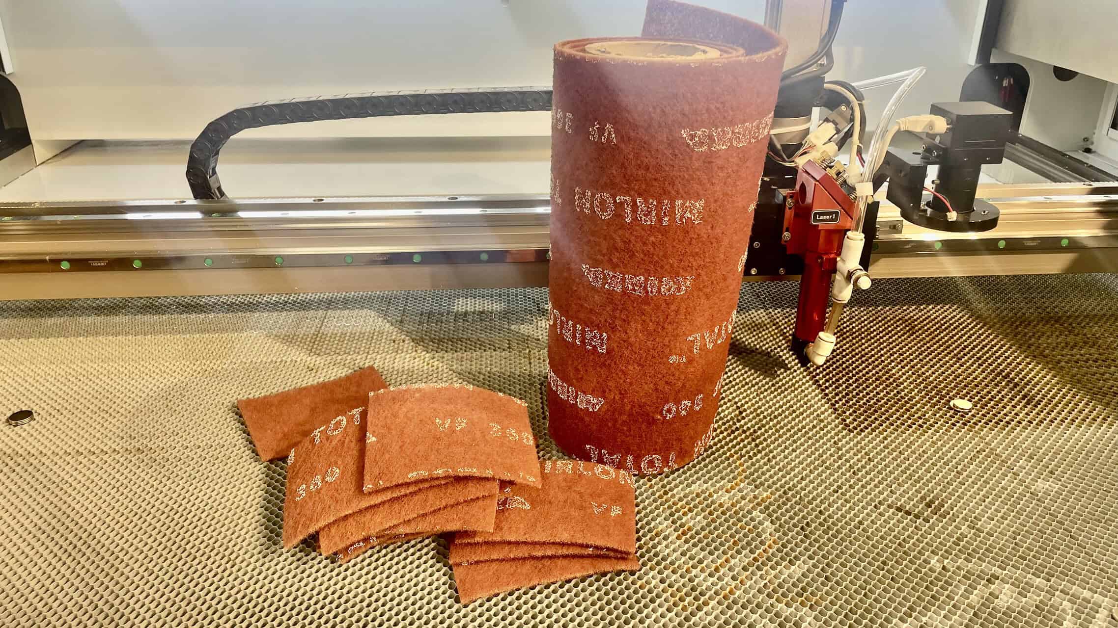 A close-up shot showing the difference between burnt natural wool felt and a cleanly fused mark on synthetic PET felt