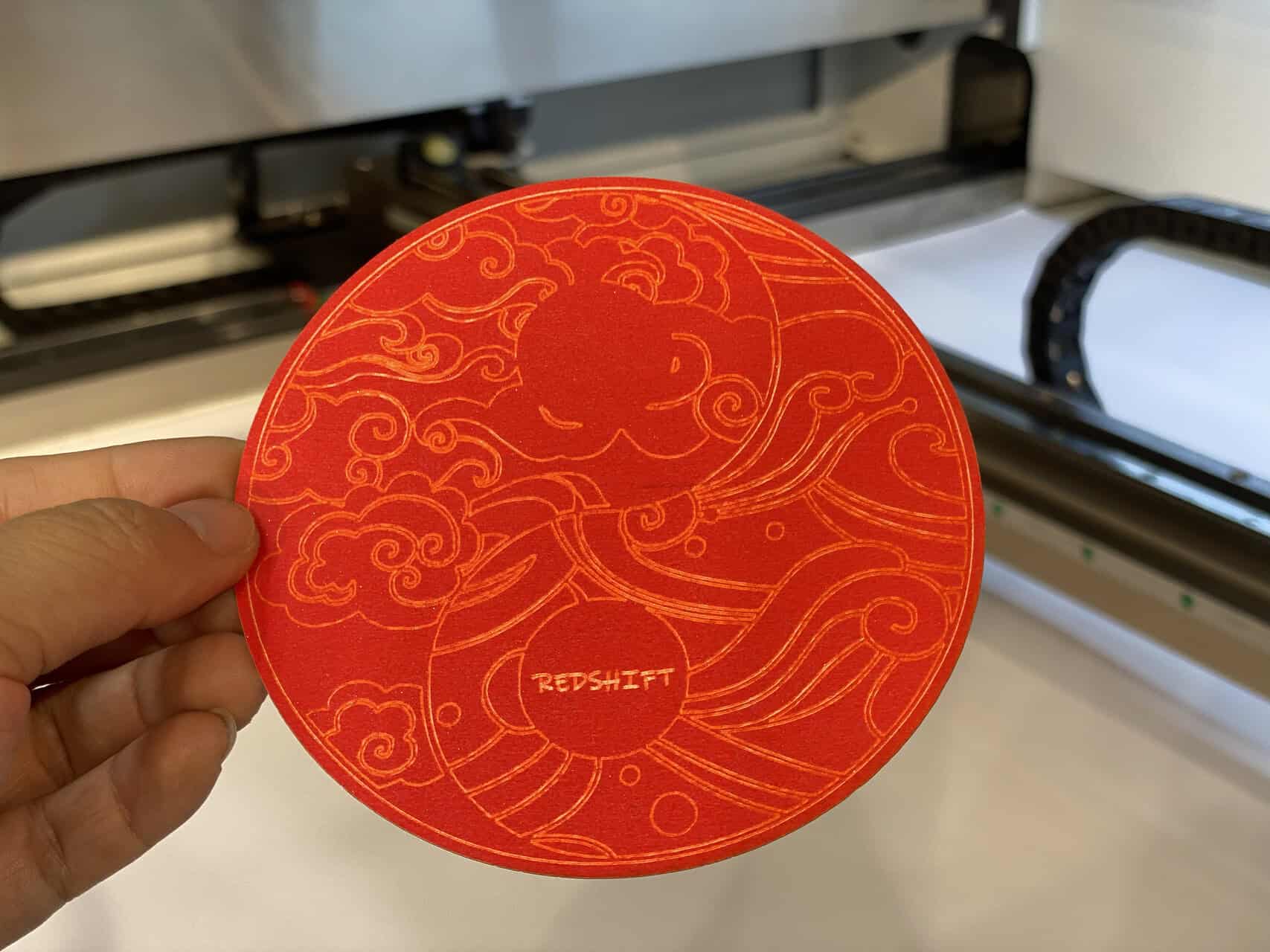 A side-by-side comparison showing a physical steel rule die next to a digital vector design on a computer screen