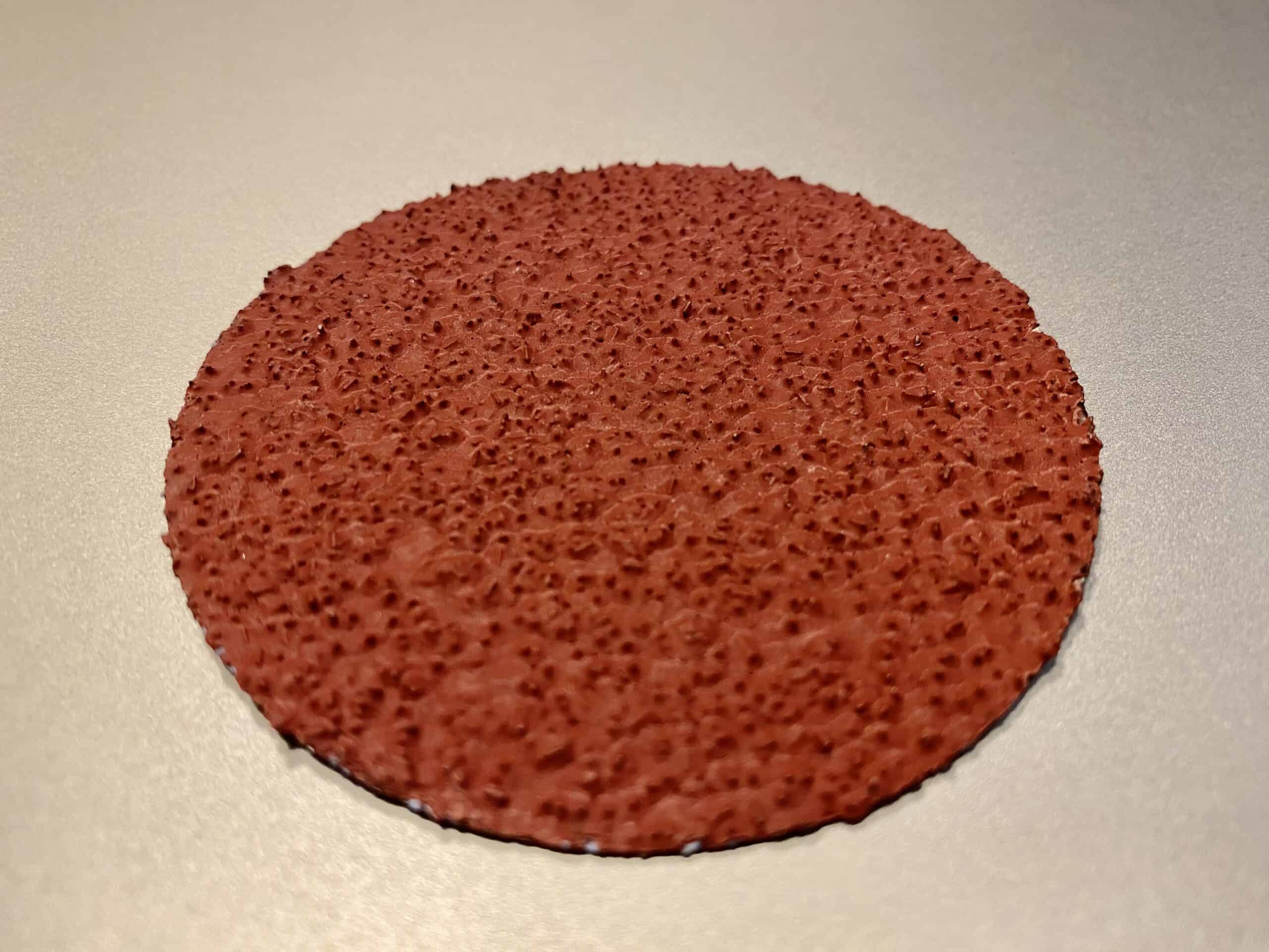 Edge Quality Comparison: Die Cut vs. Laser Cut Sandpaper A side-by-side comparison of a frayed die-cut sanding disc and a perfectly clean-edged laser-cut sanding disc